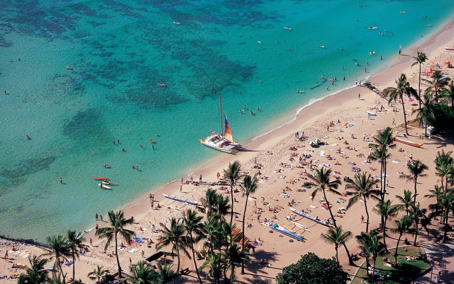 plage sable vagues légères eau palmiers gens voilier altitude paysage nature vacanciers bronzage été chaleur chaleur