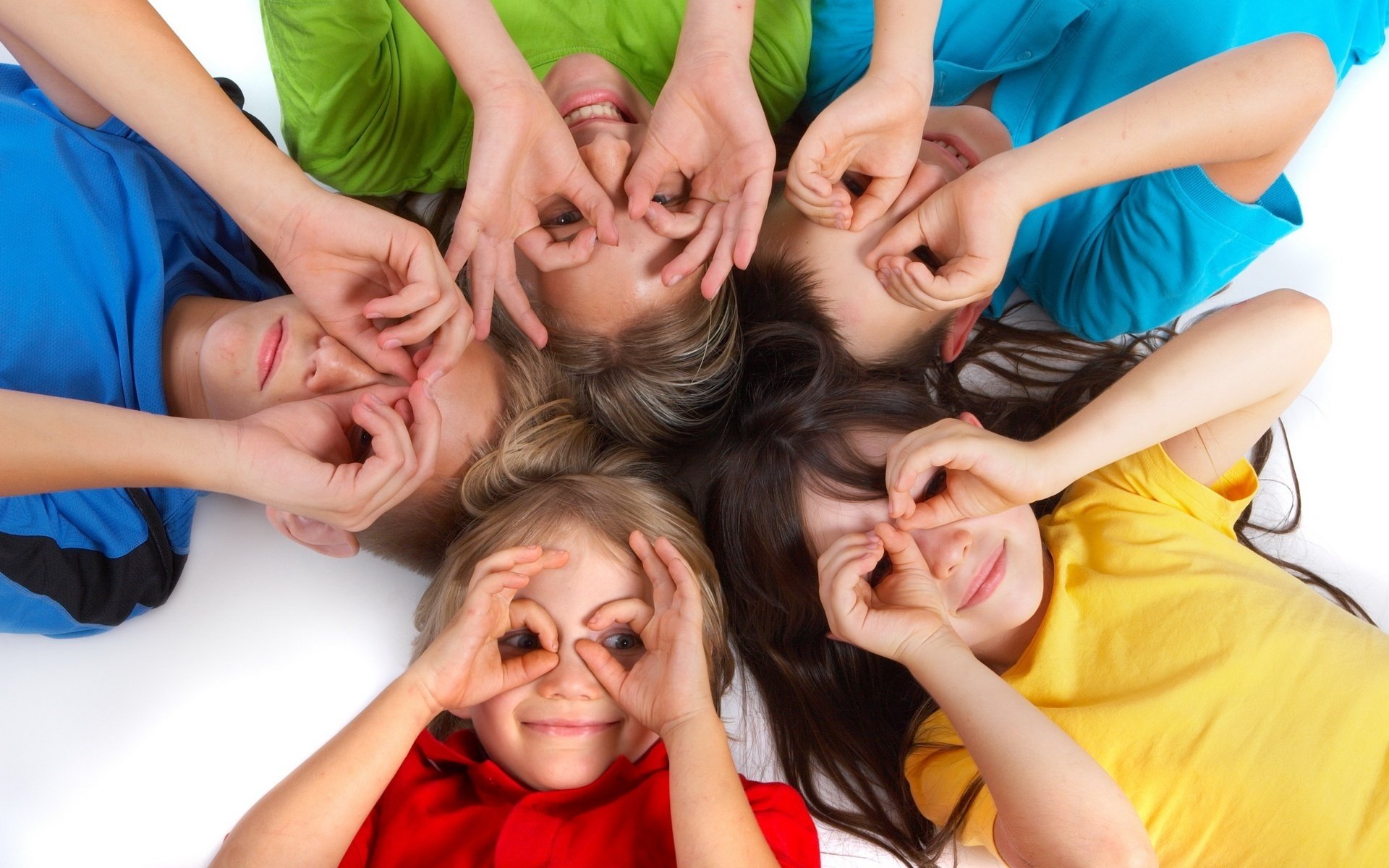 montones en la cara niños camisetas multicolores mirada estado de ánimo alegría emociones manos palmas círculo ojos cinco