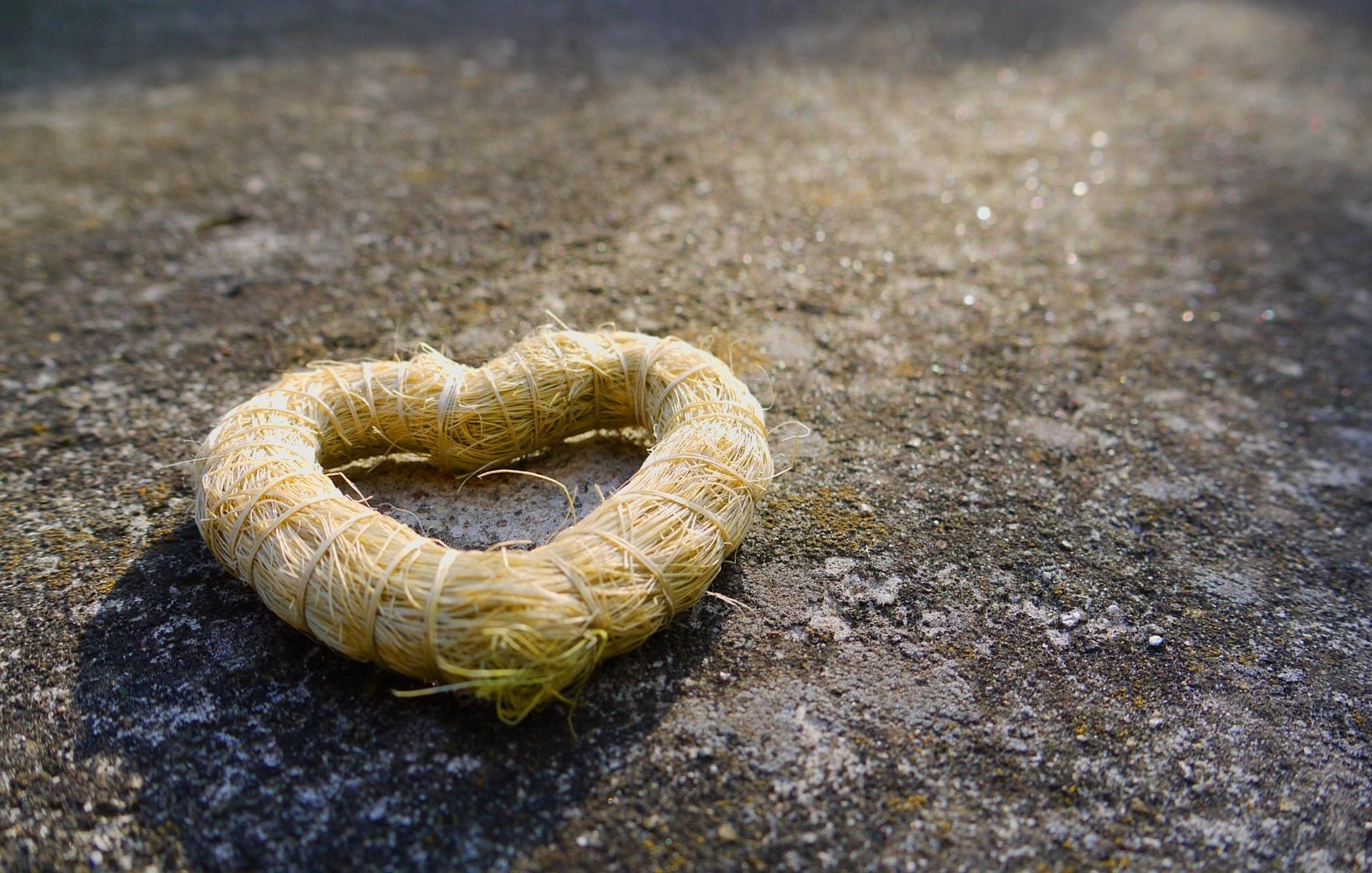 wicker heart straw on the pavement asphalt light earth heart