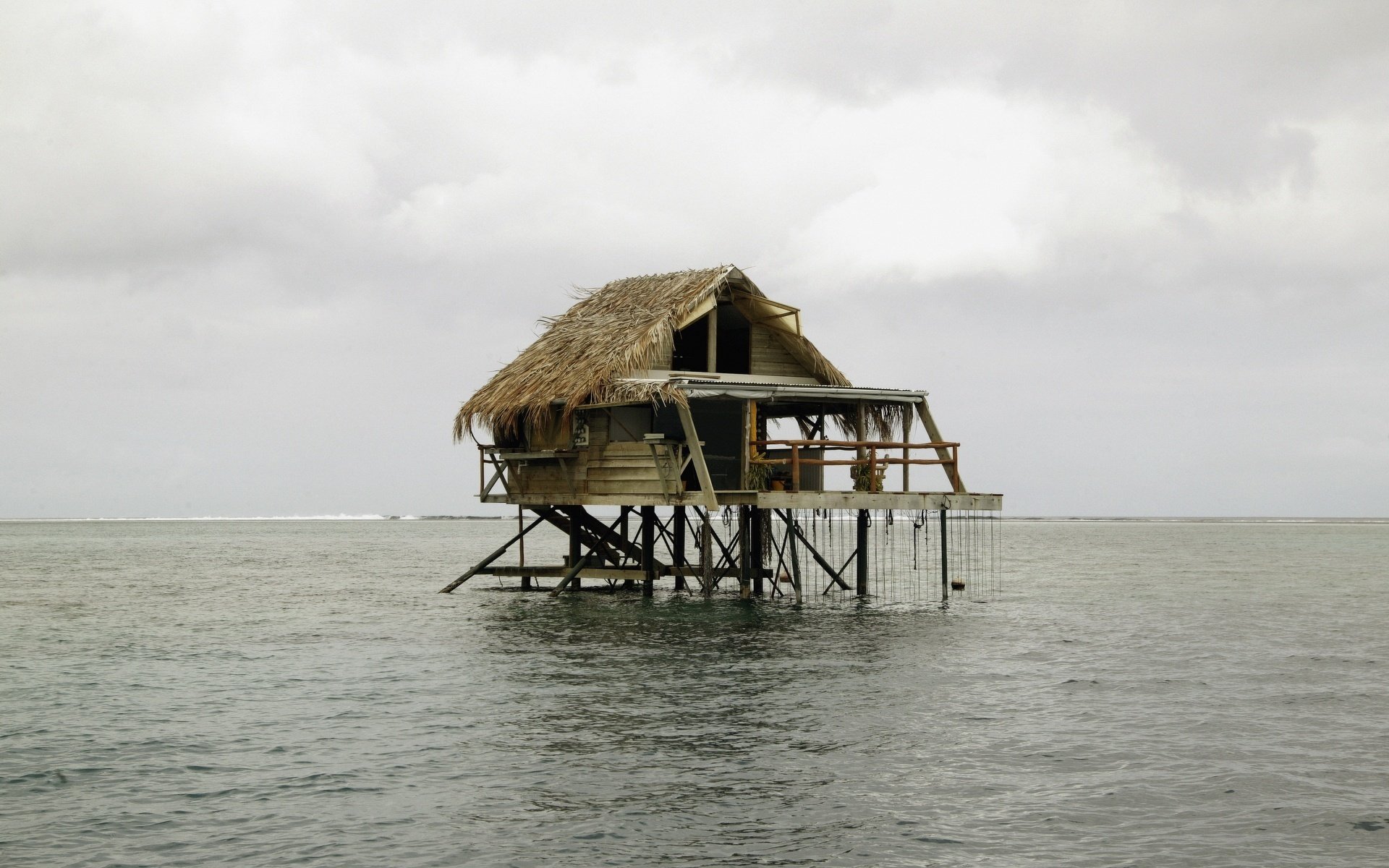wasserhaus strohdach hütte gebäude wasser inseln glatte oberfläche natur landschaft haus horizont wetterfest grauer himmel bewölkt