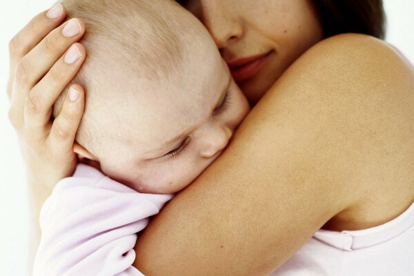A baby sleeping in his mother s arms. Maternal tenderness