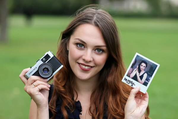 Ragazza sorridente con foto e foto in mano