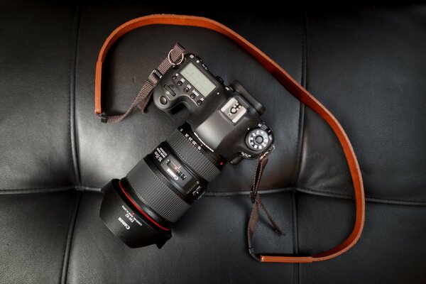 Canon s camera is lying on a leather sofa