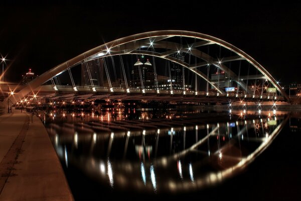 Puente colgante en el paseo marítimo de la ciudad por la noche