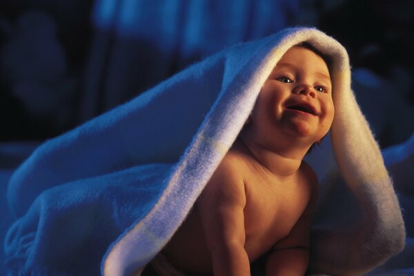 The charming baby is happy and happy in his mother s bed