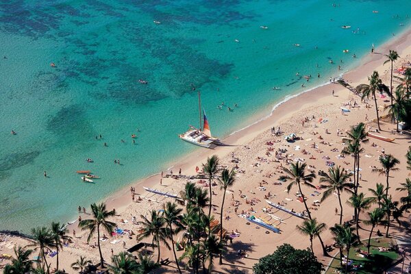 Urlauber sonnen sich und schwimmen im Meer
