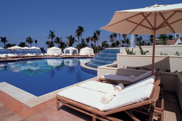 Sun beds near the pool on the territory of the hotel