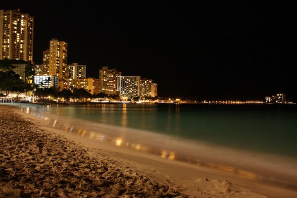 Plage de la ville avec des gratte-ciel illuminés