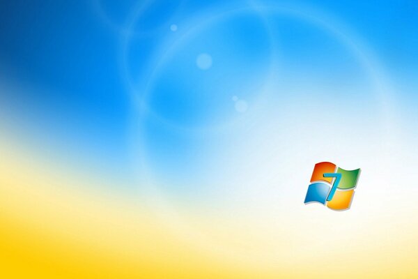 The Microsoft Windows 7 logo on a blurry background reminiscent of a wheat field and the sky