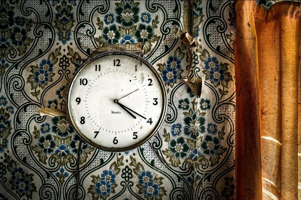 Old clock on the background of old wallpaper