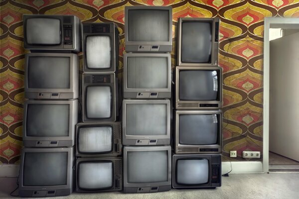 Vieux téléviseurs empilés dans la chambre