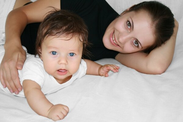 Das blauäugige Baby ist bei seiner Mutter. Familienidylle