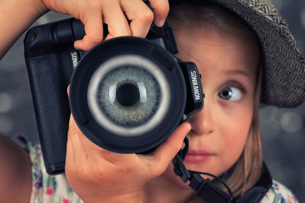 Una niña toma fotos en lugar de una lente en la cámara de los ojos