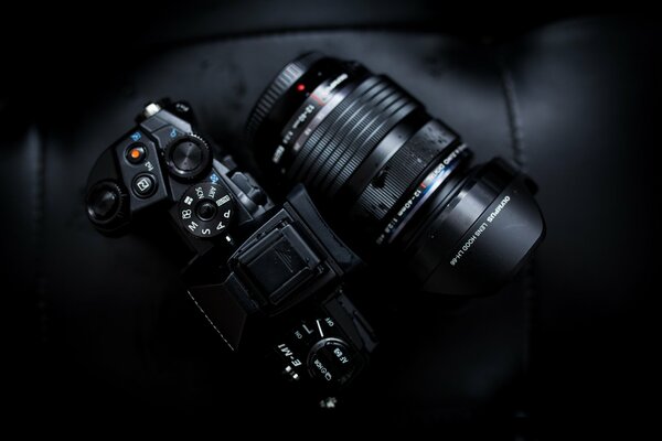 Olympus camera with a lying lens on a dark background