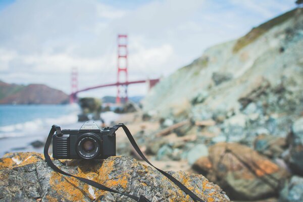 Canon camera on a stone on the background of the Golden Gate Bridge