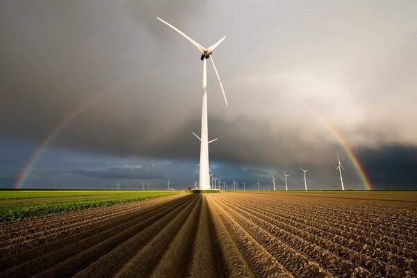 Windmills on a cloudy day against a rainbow background