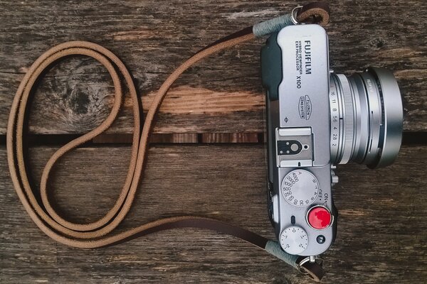 Caméra avec sangle sur fond en bois