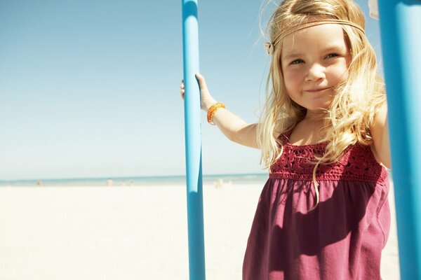 Uśmiechnięta blond dziewczyna na słonecznej plaży