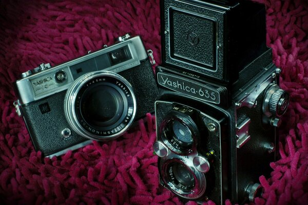 Macchina fotografica e macchina fotografica sul copriletto lavorato a maglia