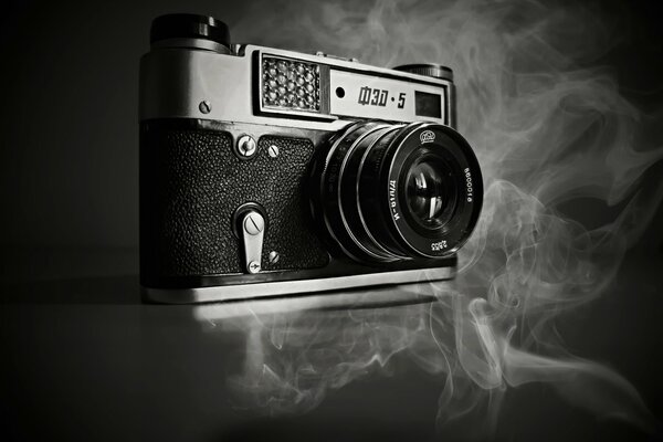 Vecchia macchina fotografica su uno sfondo di fumo grigio