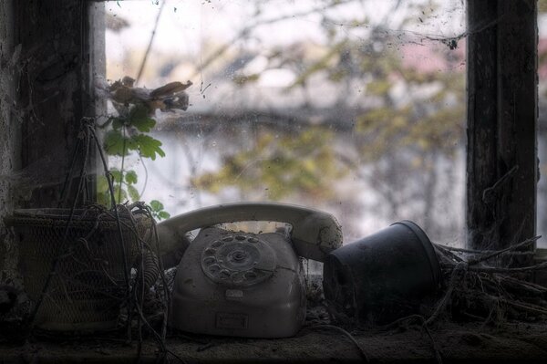 Postapokalypse. Scheibentelefon und Blumen auf der Fensterbank