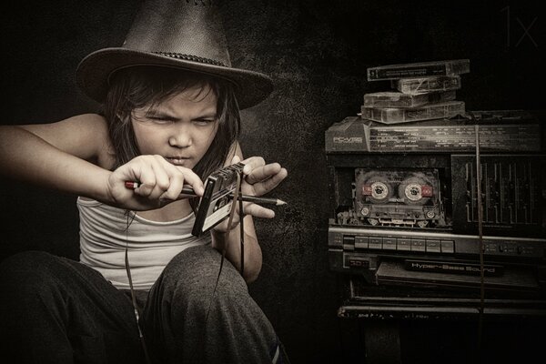 A teenage girl rewinds a tape with a pencil