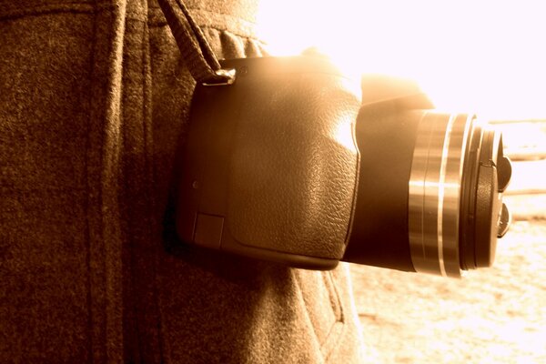 The camera weighs on a belt in the rays of the sun