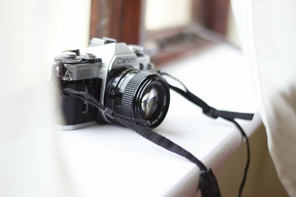 The canon camera is on the windowsill
