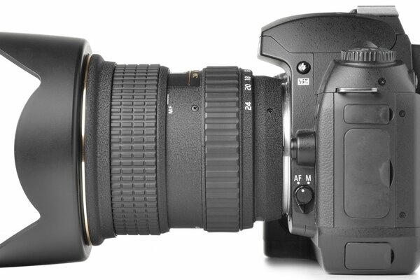 Appareil photo professionnel sur fond blanc avec objectif à focale longue