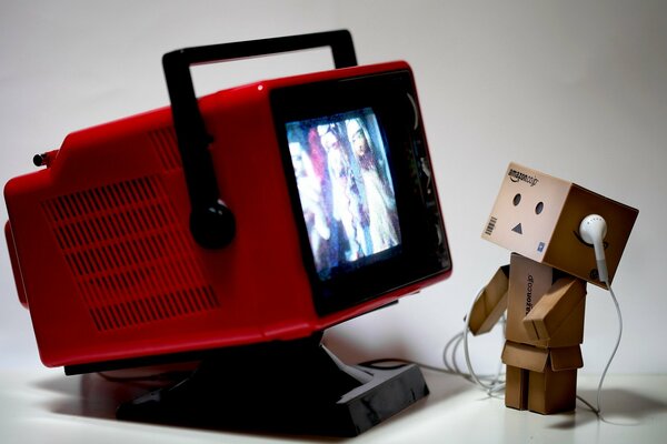 La boîte regarde la TV dans des écouteurs