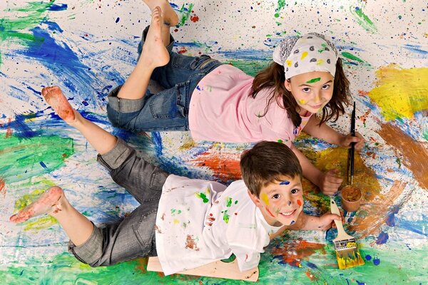 Garçon et fille peignent avec des pinceaux sur la toile
