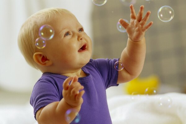 A small child catches soap bubbles