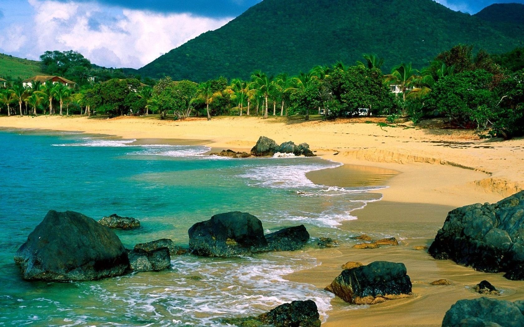 arena amarilla piedras grandes montañas playa agua costa paisaje naturaleza piedras trópicos surf mar nubes cielo olas vegetación palmeras árboles