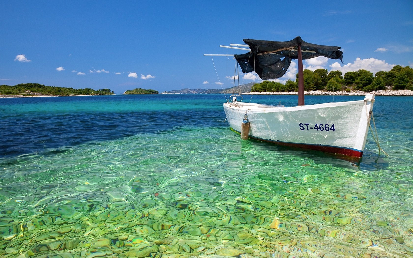 rocky bottom reflections of the sun boat water sky mountains shore sea bottom stones turquoise blue clouds summer boat island vacation resort nature