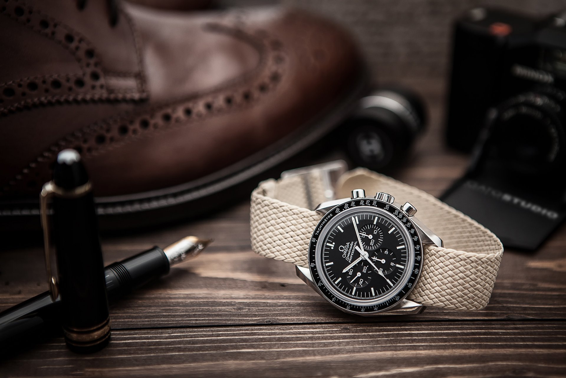 omega watches feather pen a camera shoes composition