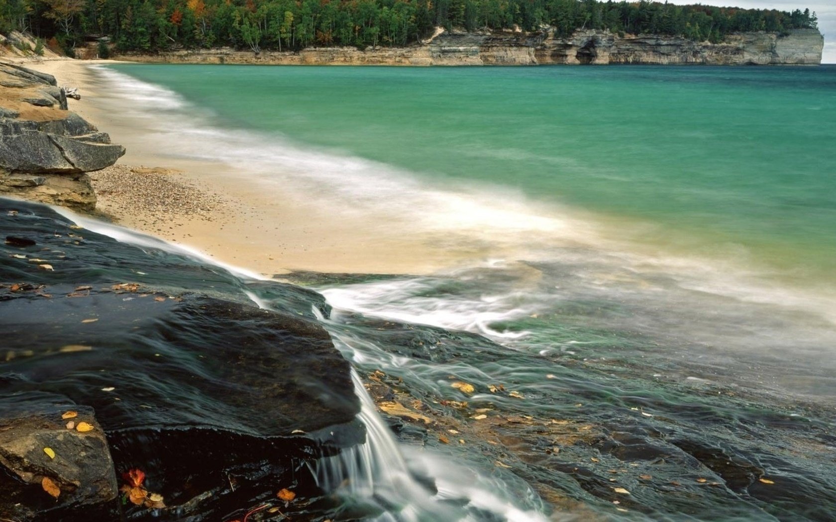 zatoka mały wodospad zarośla woda brzeg morze natura krajobraz fale wybrzeże kamienie skały plaża