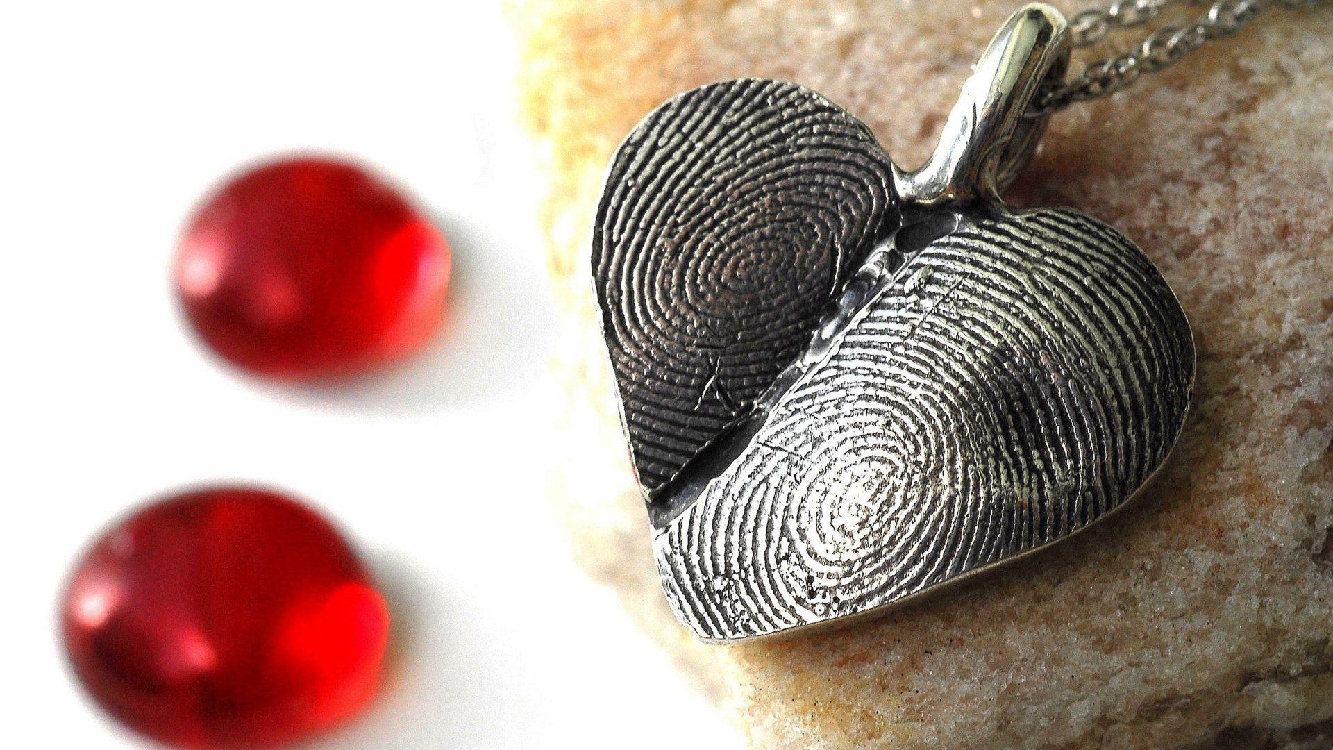 red pebble fingerprints medallion the shape of a heart pendant