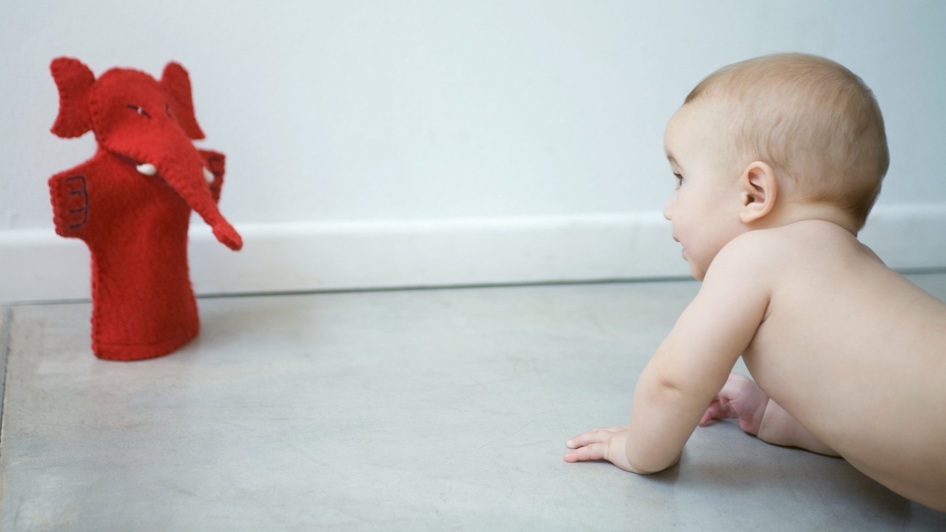 strisciando esplorando il mondo che lo circonda briciola giocattoli bambino bambino strisciando giocattolo pavimento nudo