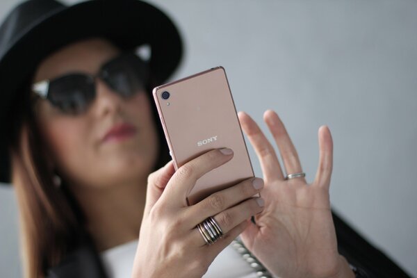 Mujer en gafas de sol es apasionada por su Smartphone