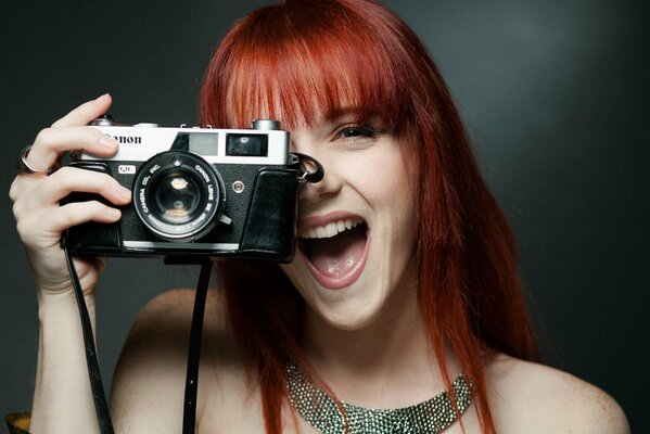 Ridere redhead ragazza con la macchina fotografica