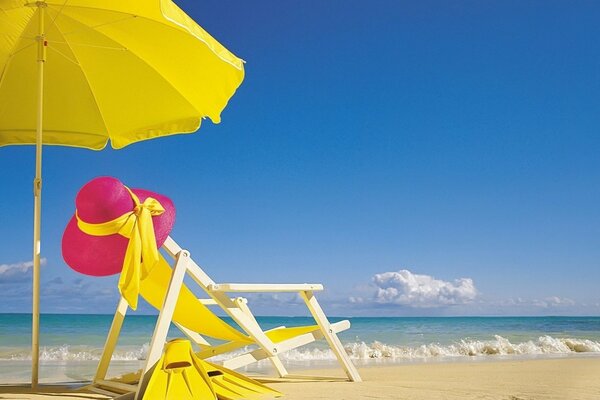 Chaise longue avec parasol sur la plage blanche