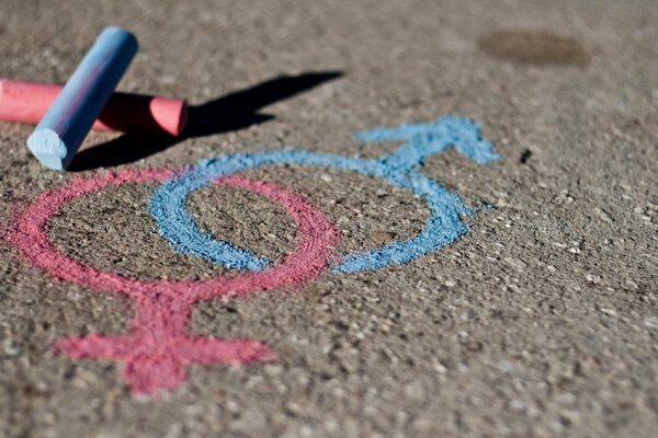 On the asphalt, pink and blue marks are drawn with the symbols of a female and a male child