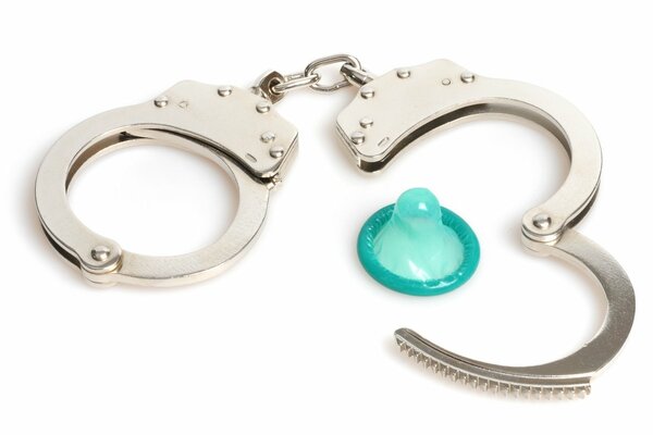 The condom is lying next to the handcuffs