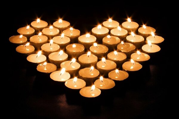 Heart-shaped candles on a dark background