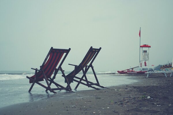 Deck chairs on a gray cloudy beach