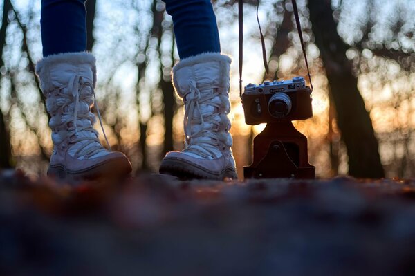 Legs together with the camera on the background of sunset