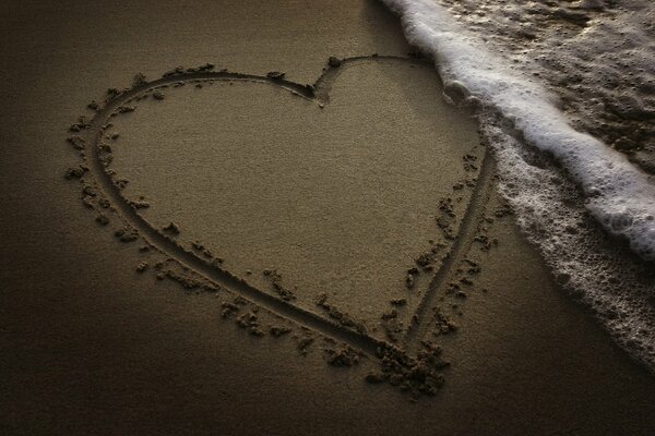 Coeur dessiné sur le sable près de la mer