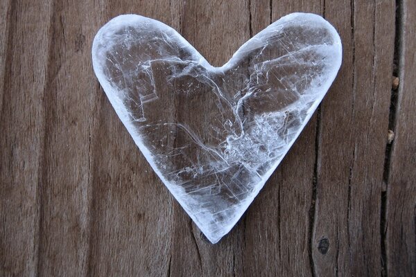 En la superficie de madera yace un hielo en forma de corazón