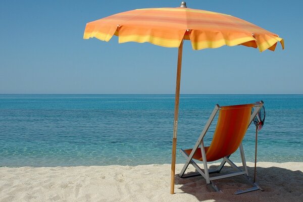 Chaise longue with umbrella on the beach