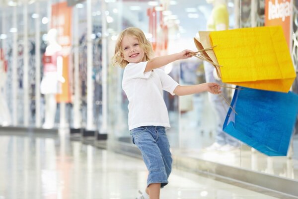 A boy with a smile on his face with bags in the store